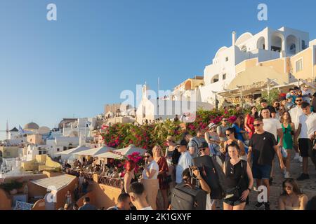 Oia, Griechenland - 11. September 2022: Enge, überfüllte und gezahnte Straßen in Oia, Santorini, füllten sich während der Sommersaison mit einer Menge Touristen Stockfoto