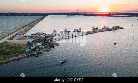 Luftaufnahme eines Hafens mit Booten, die segeln und andocken. Die Fotografie wurde von einer Drohne in einer höheren Höhe in der Sommersaison bei Sonnenuntergang aufgenommen. Stockfoto
