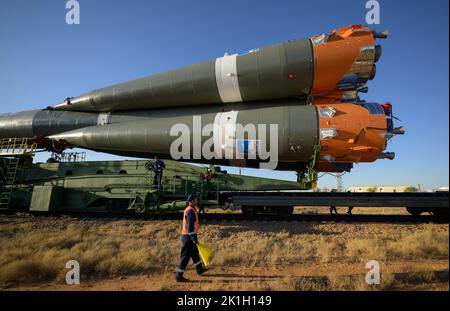 Baikonur, Kasachstan. 18. September 2022. Russische Techniker beobachten, wie die Sojus MS-22-Sonde und die Booster-Rakete per Zug ausgerollt werden, um das Flugfeld 31 des Kosmodrom Baikonur am 18. September 2022 in Baikonur, Kasachstan, zu starten. International Space Station Expedition 68 Besatzungsmitglieder Astronaut Frank Rubio von der NASA und Kosmonauten Sergey Prokopyev und Dmitri Petelin von Roskosmos werden am 21.. September in das Orbiting-Labor starten. Quelle: Bill Ingalls/NASA/Alamy Live News Stockfoto