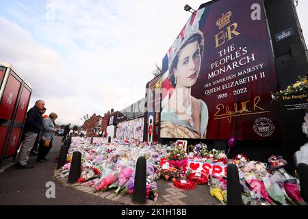 Nach dem Tod des britischen Monarchen legt man Blumen auf ein Wandgemälde, das Königin Elizabeth II. Auf der Shankill Road in Belfast darstellt. Stockfoto