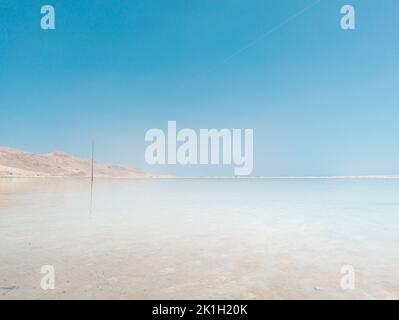 Landschaftsblick auf Salzkristalle des Toten Meeres, klares, cyangrünes Wasser am Strand ein Bokek, Israel Stockfoto