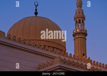 Minarett und Kuppel der muslimischen islamischen Moschee auf Sonnenuntergang Hintergrund. Minarettturm und Dachkuppel mit traditionellem Halbmond Stockfoto