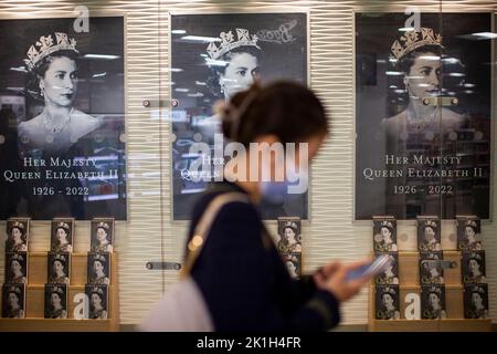 London, Großbritannien. 18. September 2022. Eine junge Dame geht am Sonntagabend in einem Buchladen in Kings Cross St Pancras an der Ausstellung von Büchern von Andrew Morton über Königin Elizabeth II vorbei. Kredit: Windmill Images/Alamy Live Nachrichten Stockfoto