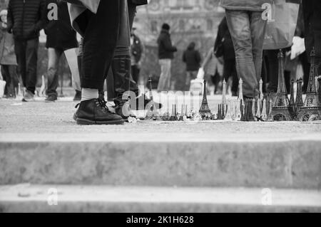 Ein Stand mit kleinen Eiffeltürmen, Souvenirs auf dem Platz vor dem Eiffelturm in Paris, Frankreich Stockfoto