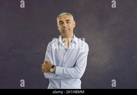 Porträt eines glücklichen Mannes mittleren Alters auf schwarzem Hintergrund Stockfoto