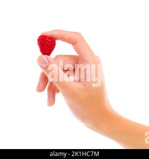 Köstliche Quelle von Vitaminen. Beschnittene Studioaufnahme einer Frau, die eine Himbeere isoliert auf Weiß hält. Stockfoto