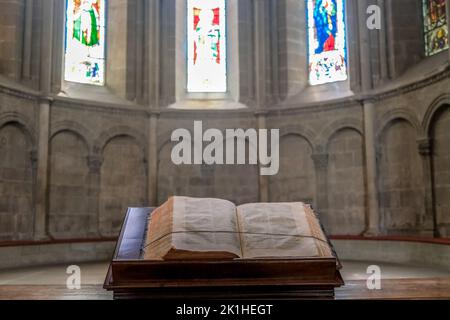 Eine offene bibel auf einem Rednerpult in einer wunderschön beleuchteten religiösen Kapelle. Stockfoto