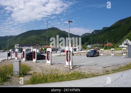 Lavik, Norwegen - 24. Juni 2022: Eine statische Aufnahme eines schwarzen Tesla Model 3 Dual Motor, der an einem sonnigen Sommertag am Lavik Supercharger geladen wird. Auswahl Stockfoto