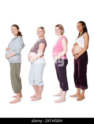 Wir freuen uns darauf, ihre Babys zu bekommen. Schwangere stehen zusammen, während sie isoliert auf Weiß stehen. Stockfoto