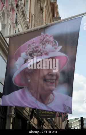 London, Großbritannien. 18.. September 2022. Ein Bild der verstorbenen Königin Elizabeth II hängt an einem Fahnenmast, der an der Buchhandlung Hatchards auf Piccadilly hängt. Kredit: Sarah Peters/Alamy Live Nachrichten Stockfoto