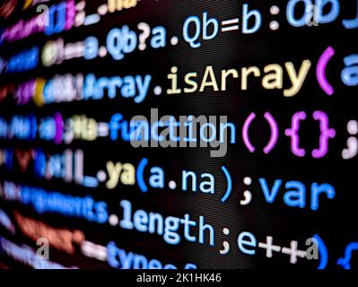 Nahaufnahme des Softwarecodes auf einem Computerbildschirm mit farbigen Buchstaben und Zahlen, die im dunklen Modus auf schwarzem Hintergrund angezeigt werden Stockfoto