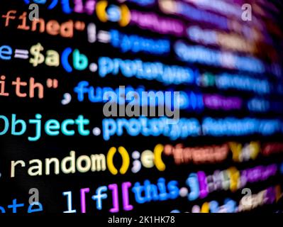 Pixelige Computercodelinien, die auf einem digitalen Bildschirm mit unscharfem Fokus-Hintergrund angezeigt werden Stockfoto