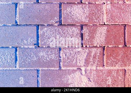 Blauer bis roter Gradient überlagert auf sandbestreuten Pflasterplatten, selektiver Fokus Stockfoto