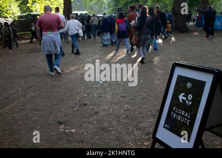 Menschenmengen, die in den Green Park mit einem Schild in Richtung der Blumenbeweise nach dem Tod der Queen, London England, fahren Stockfoto