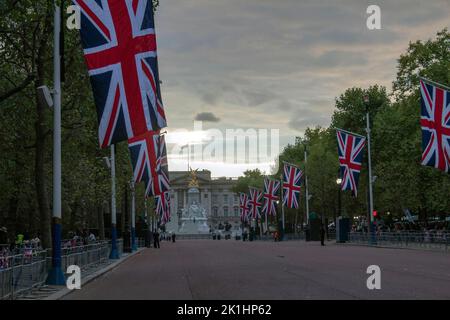 In der Mall mit Blick auf den Buckingham-Palast säumen Unionsflaggen, während sich die Menschen darauf vorbereiten, über Nacht auf das Begräbnis der Königin am nächsten Tag, London, Großbritannien, zu warten Stockfoto