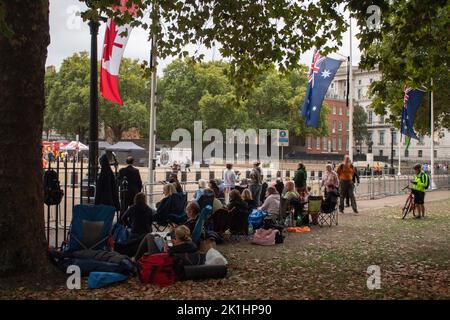 Menschen, die unter den Flaggen des Commonwealth kampieren, säumen am 18. September 2022 die Beerdigungsroute der Queen, Horse Guards Road, London, Großbritannien Stockfoto