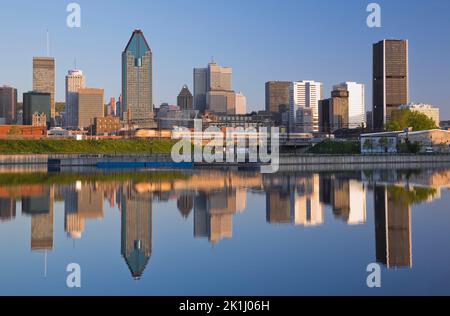 Die Skyline von Montreal spiegelt sich im Peel Basin bei Sonnenaufgang im Frühjahr, Quebec, Kanada. Stockfoto