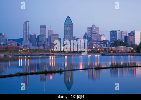 Die beleuchtete Skyline von Montreal spiegelt sich im Peel Basin bei Sonnenaufgang im Frühjahr, Quebec, Kanada. Stockfoto