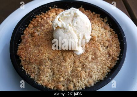 Traditionelles türkisches Dessertgrieß Halva (türkisch: Irmik helvasi) mit Eis auf dem Dessertteller. Stockfoto