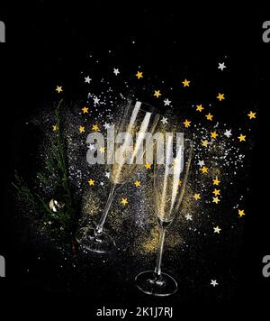 Zwei Sektgläser. Weihnachtsdekoration auf schwarzem Hintergrund. Frohes Neues Jahr. Draufsicht. Stockfoto