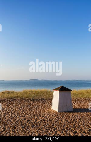 Hölzerne Umkleidekabine oder Hütte am leeren und sandigen Strand von Tulliniemi in Hanko, Finnland, an einem sonnigen Morgen im Sommer. Speicherplatz kopieren. Stockfoto