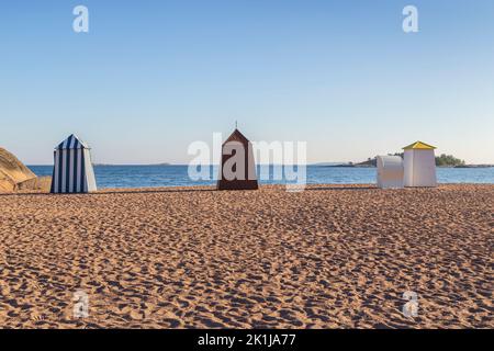 Hölzerne Umkleidekabinen oder Hütten am leeren und sandigen Casino-Strand in der Innenstadt von Hanko, Finnland, an einem sonnigen Tag im Sommer. Stockfoto