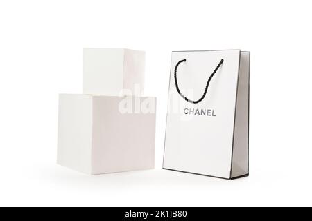 Zypern, Paphos - 08. SEPTEMBER 2022: Komposition aus Markenpapierbeutel des Chanel Parfümerieladens neben weißen Würfeln. Auf weißem Hintergrund. Stockfoto