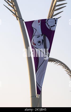 Doha, Katar - 5. September 2022: Eine Flagge, die die FIFA Fußball-Weltmeisterschaft 2022 fördert, rollt auf einem Laternenposten in der West Bay Area in Doha, Katar. Stockfoto