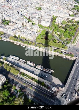 Paris, Frankreich - 18. April 2022: Der Eiffelturm wirft seinen Schatten auf die seine und das 16. Arrondissement darunter. Stockfoto