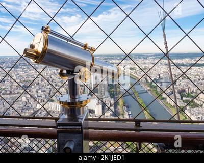 Paris, Frankreich - 18. April 2022: Eines der mit Münzen betriebenen Vintage-Teleskope auf der Aussichtsplattform auf dem Eiffelturm. Stockfoto