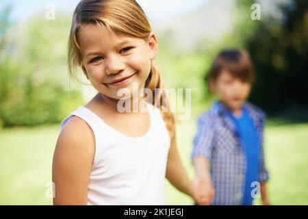 Komm schon, lass los spielen. Ein junges Mädchen und ein Junge halten die Hände. Stockfoto