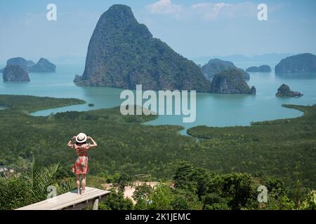 Glückliche Reisende Frau genießen Phang Nga Bucht Aussichtspunkt, allein Tourist Stand und Entspannung in Samet Nang She, in der Nähe von Phuket in Südthailand. Southeas Stockfoto