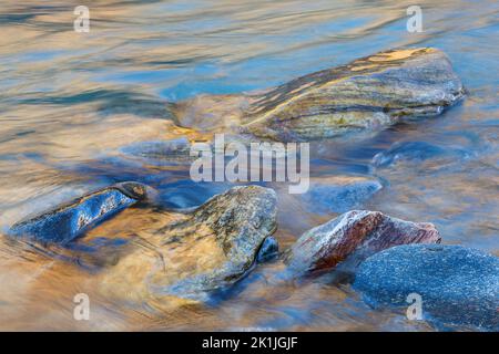 Fließendes Wasser mit Felsen in einem Bach Stockfoto
