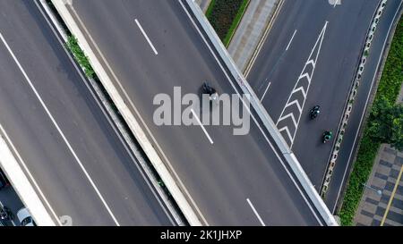 Luftaufnahme einer mehrstufigen Straßenkreuzung in der Stadt Jakarta an sonnigen Sommertagen mit leichtem Verkehr von oben nach unten Stockfoto