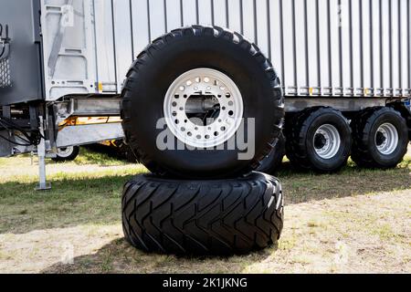 LKW-Räder warten auf Wechsel. Neue LKW-Reifen auf dem Hintergrund eines großen Anhängers. Stockfoto