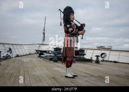 Edinburgh, Großbritannien. 19. September 2022. Rohrmajor Steven Dewar von Scotia Pipers begrüßt ihre Majestät Königin Elizabeth II., die am 8.. September an Bord der Royal Yacht Britannia vertäut in Leith Docks in Edinburgh, Großbritannien, starb. 19. September 2022. Foto: Jeremy Sutton-Hibbert/Alamy Live News. Stockfoto