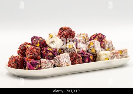 Gemischter türkischer Genuss. Auswahl an türkischen Delight mit Pistazien isoliert auf weißem Hintergrund. Traditionelle Köstlichkeiten der mittelöstlichen Küche. Schließen Stockfoto