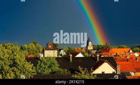 Ein Regenbogen hinter der Kirche von Herleshausen in Hessen Stockfoto