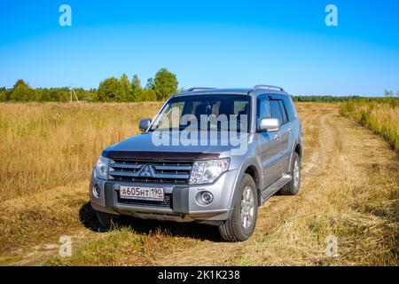 Region Moskau. Russland. 15. September 2022. Mitsubishi Pajero 4 Auto auf einer Landstraße auf einem Feld an einem sonnigen Herbsttag. Ein Ausflug in die Natur mit einem Geländewagen. Stockfoto