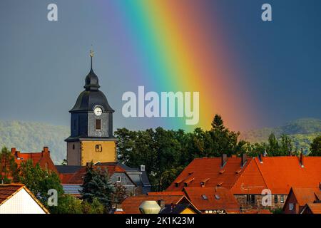 Ein Regenbogen hinter der Kirche von Herleshausen in Hessen Stockfoto