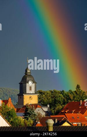 Ein Regenbogen hinter der Kirche von Herleshausen in Hessen Stockfoto