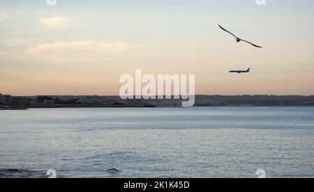 Palma, Spanien. 19. September 2022. Ein Verkehrsflugzeug, das sich bei Sonnenaufgang dem Flughafen Palma de Mallorca nähert. Nach den Regenfällen Anfang September werden die Temperaturen in den nächsten Tagen voraussichtlich steigen. Quelle: Clara Margais/dpa/Alamy Live News Stockfoto