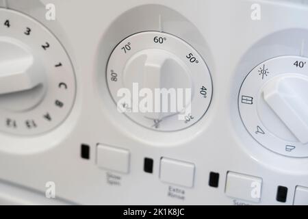 Nahaufnahme von 60 Grad auf der Vorderseite einer Waschmaschine, Tasten und Drehräder. Konzept - tun Sie die Wäsche, Energieeinsparung, Strompreis, Energieeffizienz Stockfoto