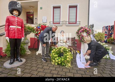 Deutschland. 19. September 2022. 19. September 2022, Rheinland-Pfalz, Vettelschoß: Gary Blackburn und seine Frau Monica, Betreiber des Themenhotels Little Britain Inn, legen einen Kranz vor eine Statue der Königin. Das Themenhotel, auf dessen Außengelände zahlreiche britische Exponate von Doppeldeckerbussen bis hin zu Panzern ausgestellt sind, verfügt auch über einen Queens Room. Foto: Thomas Frey/dpa Quelle: dpa picture Alliance/Alamy Live News Stockfoto