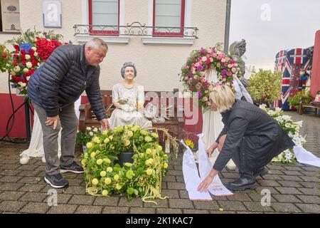 Deutschland. 19. September 2022. 19. September 2022, Rheinland-Pfalz, Vettelschoß: Gary Blackburn und seine Frau Monica, Betreiber des Themenhotels Little Britain Inn, legen einen Kranz vor eine Statue der Königin. Das Themenhotel, auf dessen Außengelände zahlreiche britische Exponate von Doppeldeckerbussen bis hin zu Panzern ausgestellt sind, verfügt auch über einen Queens Room. Foto: Thomas Frey/dpa Quelle: dpa picture Alliance/Alamy Live News Stockfoto