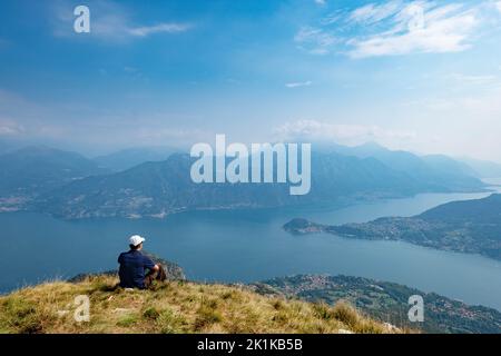 Mann auf dem Monte Crocione mit Blick auf den Comer See, Lugano Prealps, Lombardei, Italien Stockfoto