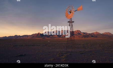 Windmühle pumpt Wasser in der ländlichen Outback-Landschaft, Australien Stockfoto