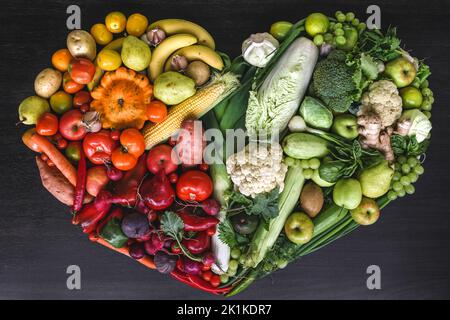 Herz aus frischem Gemüse und Obst auf Holzhintergrund. Stockfoto