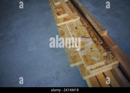 Draufsicht auf Bauholzplatten auf Betonboden, Konzept des Öko-Hauses, gesundes Wohnen und grüne Architektur. Stockfoto