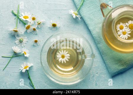 Kamillentee. Kamillenaufguss in einer Tasse mit einer Teekannen, natürliches Heilmittel, darüber liegende flache Schuss Stockfoto